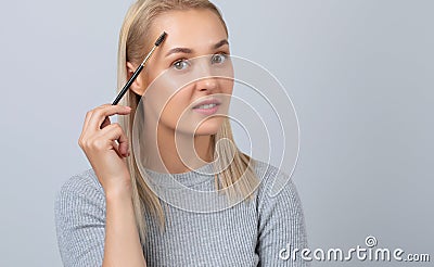 A girl combs her eyebrows with a brush after dyeing in a beauty salon.Professional makeup and cosmetology skin care Stock Photo