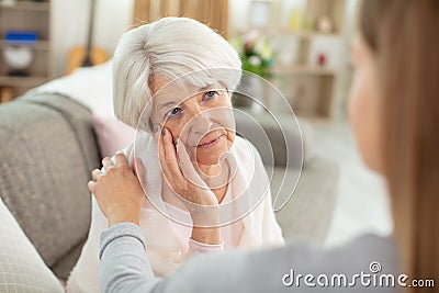 girl comforting distressed elderly woman Stock Photo