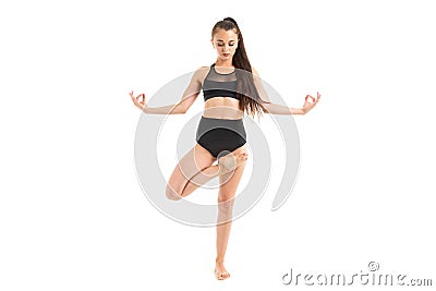 Girl is concentrated on yoga in a black sports swimsuit on a white background Stock Photo