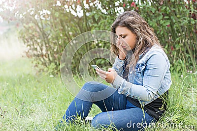 The girl is crying looking at her smart phone. Stock Photo