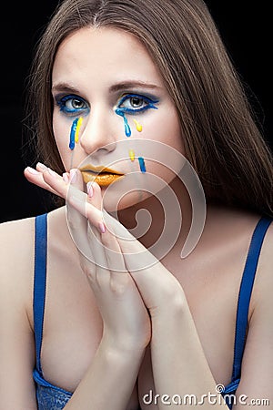 Girl crying yellow blue tears. Stock Photo