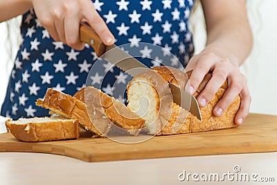 Girl cut bread with knife Stock Photo