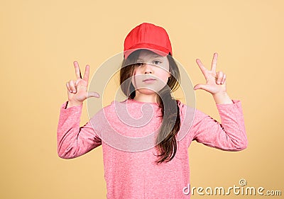 Girl cute child wear cap or snapback hat beige background. Little girl wearing bright baseball cap. Modern fashion. Kids Stock Photo