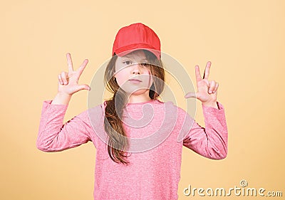 Girl cute child wear cap or snapback hat beige background. Little girl wearing bright baseball cap. Modern fashion. Kids Stock Photo