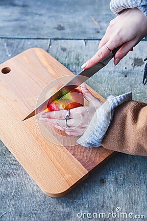 Girl cuts an apple in the forest Stock Photo