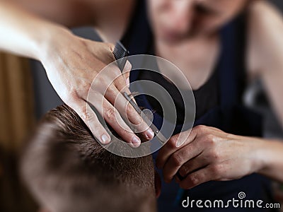 Girl cuts guy with scissors and comb, hairdresser concept Stock Photo