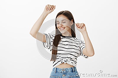 Girl dancing in her room alone. Portrait of sensual romantic attractive woman with brown hair, raising hands and making Stock Photo