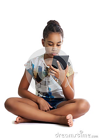 Girl, dark-skinned teenager looks at the screen of the tablet Stock Photo