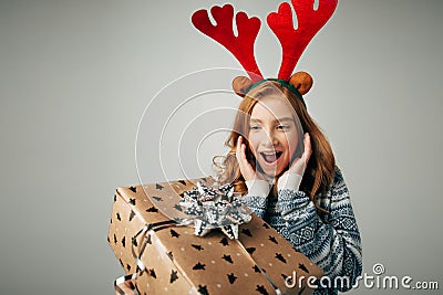 Girl with deer horns in a sweater smiles. She is shocked by such a great gift. Parents pleasantly surprised the teenager Stock Photo