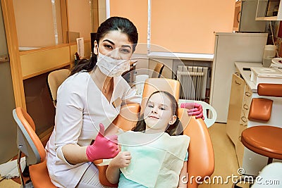 Pediatric dentistry. Dentist and girl look at the camera and smile Stock Photo