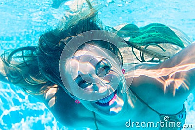 Girl diving underwater in swimming pool Stock Photo