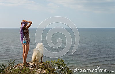 Girl and dog standing on precipice Stock Photo