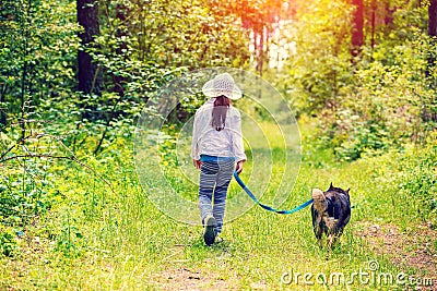 Girl with dog walking in the forest Stock Photo