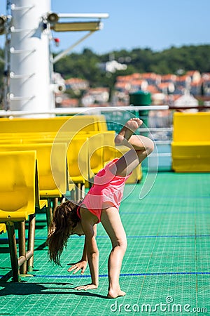 Girl doing cartwheels on Croatian ferryboat in Mali Losinj Stock Photo