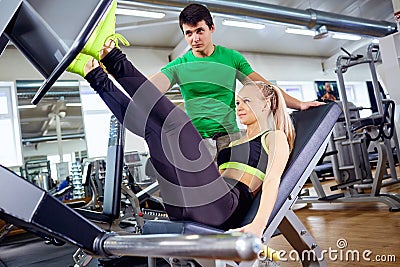 A girl is doing exercises on the foot simulator with personal t Stock Photo