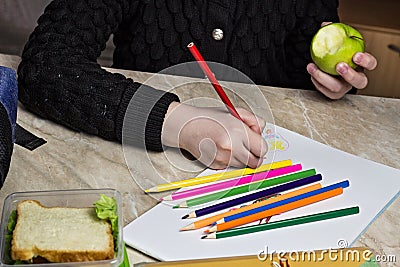 Girl doing homework and eating apple, close up sandwich Stock Photo