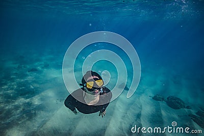 A girl doing snorkeling in tropical water Stock Photo