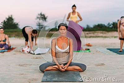 Girl doing yoga at the beach, at sunset time. Time for yoga. Attractive and-healthy young-woman doing exercises on the beach at su Editorial Stock Photo