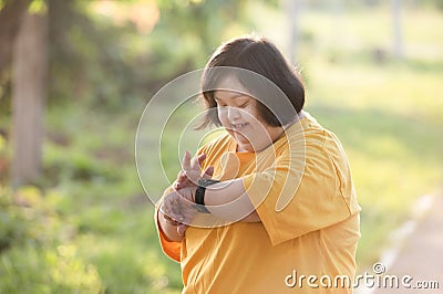 Girl with Down syndrome or autism looking at the time Stock Photo