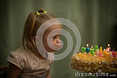 Girl with Down syndrome blows out the candles on her birthday cake Stock Photo