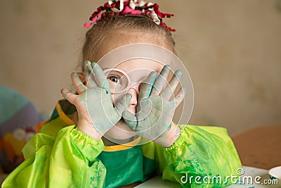 Girl with Down syndrome covered in paint when drawing Stock Photo