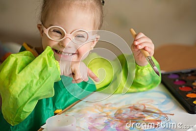 Girl with Down syndrome draws paints Stock Photo