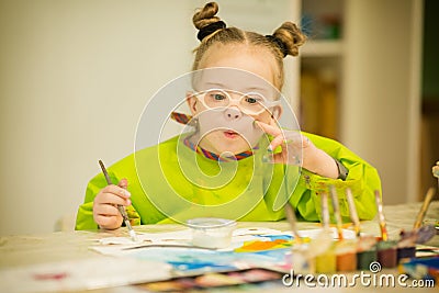 Girl with Down syndrome draws paints Stock Photo