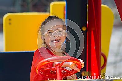 Girl with Down syndrome having fun on the playground Stock Photo