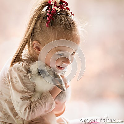 Girl with Down syndrome hugs rabbit Stock Photo