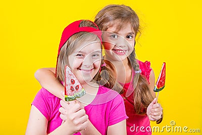 Girl Down syndrome and little girl with large Lollipop Stock Photo