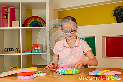 A girl with Down syndrome plays with popit Stock Photo