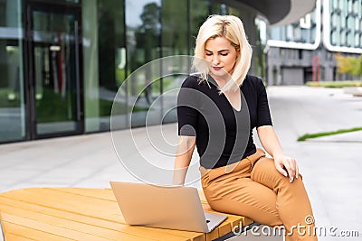 Young business woman working at the computer in cafe. Young girl downshifter working at a laptop, working day. Stock Photo