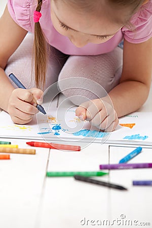 The girl draws with crayons in the album Stock Photo