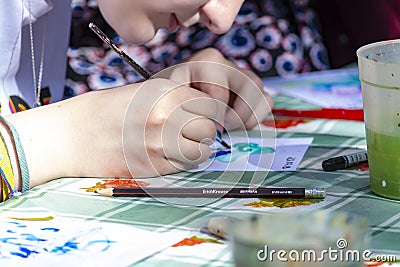 Girl draws paints on paper. Holiday Marine Festival in the open. Editorial Stock Photo