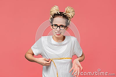 Girl with dreads in a white shirt and glasses looking is upset measuring her boobs Stock Photo