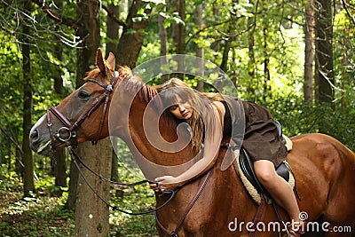 Girl in dress and brown horse portrait in forest Stock Photo