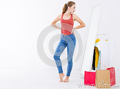 Girl dress up and try on clothes looking in mirror. Shopping and weight loss concept. Copy space. Blank template background. Body Stock Photo