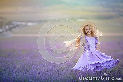 A girl in a dress whirls and dances in a natural lavender field Stock Photo