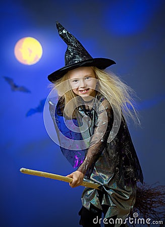 Girl dressed up as witch in night flying broom Stock Photo