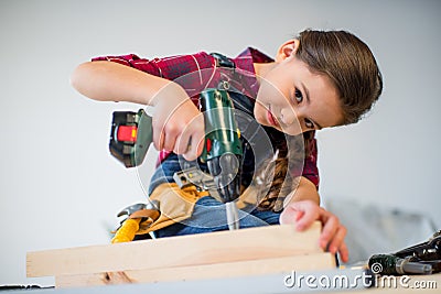 Girl drilling plank Stock Photo