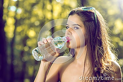 Girl drinking water from bottle in nature Stock Photo