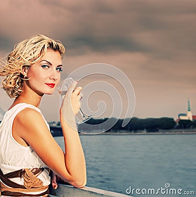 Girl drinks champagne near the river Stock Photo