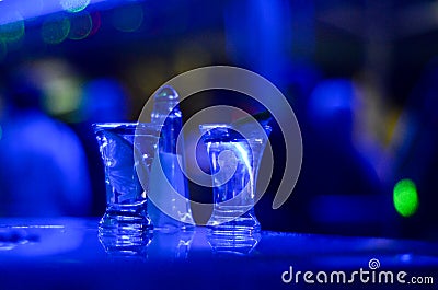 Girl drinks shot of tequila. Limes, salt and shots on table in nightclub. Hand of girl holding glass of alcohol drink in pub. Lady Stock Photo