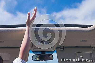 Girl driver traveling by car and holds her hand out from open hatch of a vehicle. Stock Photo