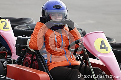 Girl is driving Go-kart car with speed in a playground racing track. Stock Photo