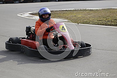 Girl is driving Go-kart car with speed in a playground racing track. Stock Photo