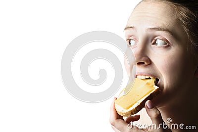 Girl eagerly eats a sandwich with cheese and butter. Close-up. Isolate on white background. Copy space Stock Photo