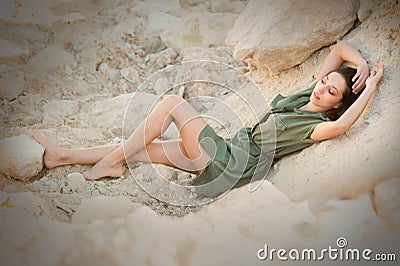 girl of eastern appearance in khaki dress on the sand Stock Photo