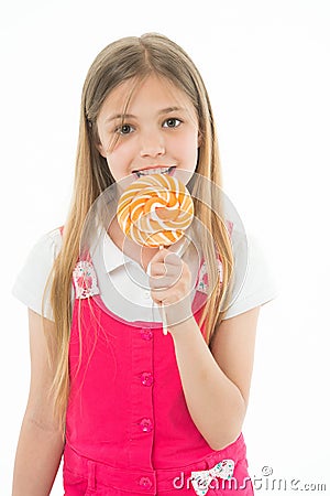 Girl eat lollipop isolated on white. Little child enjoy candy on stick. Happy kid smile with swirl caramel. Candyshop Stock Photo