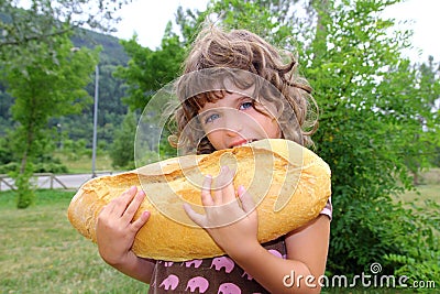 Girl eating big bread humor size hungry child Stock Photo